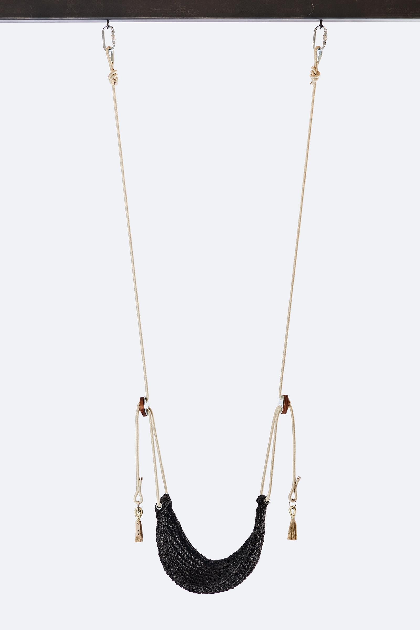 Black woven swing with beige chains on a white background