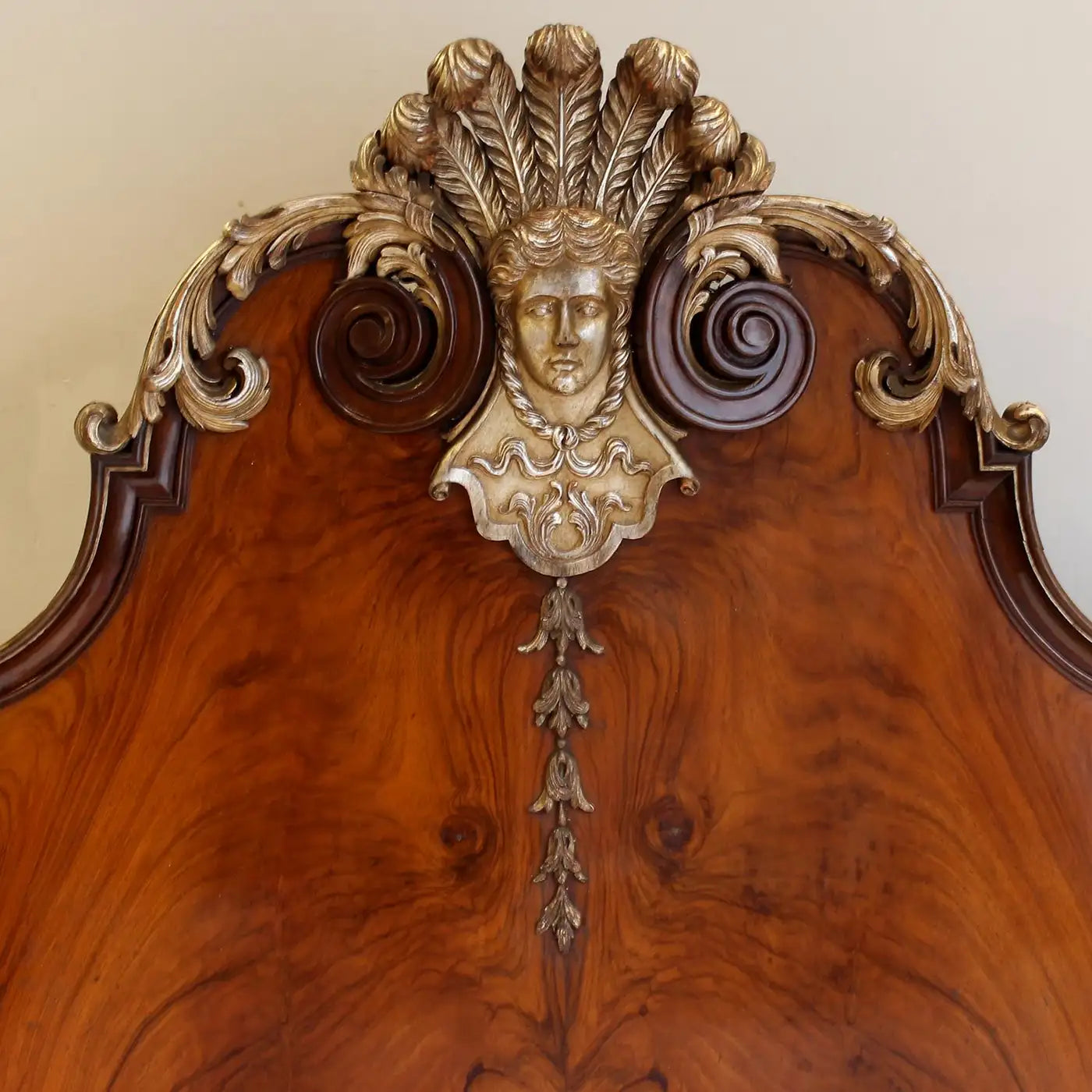 Decorative wooden headboard with gold leaf and face carving