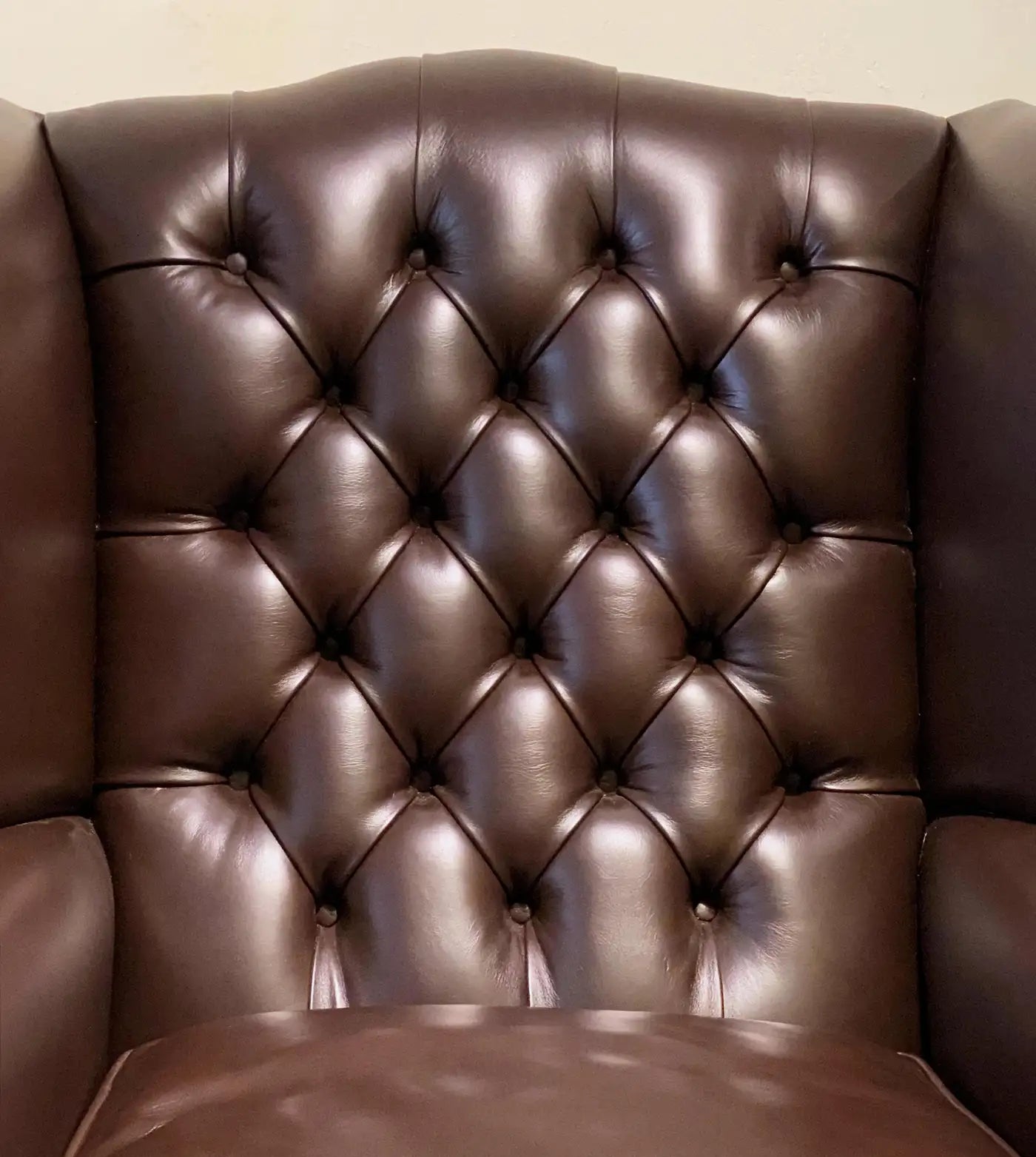 Brown leather armchair with tufted backrest