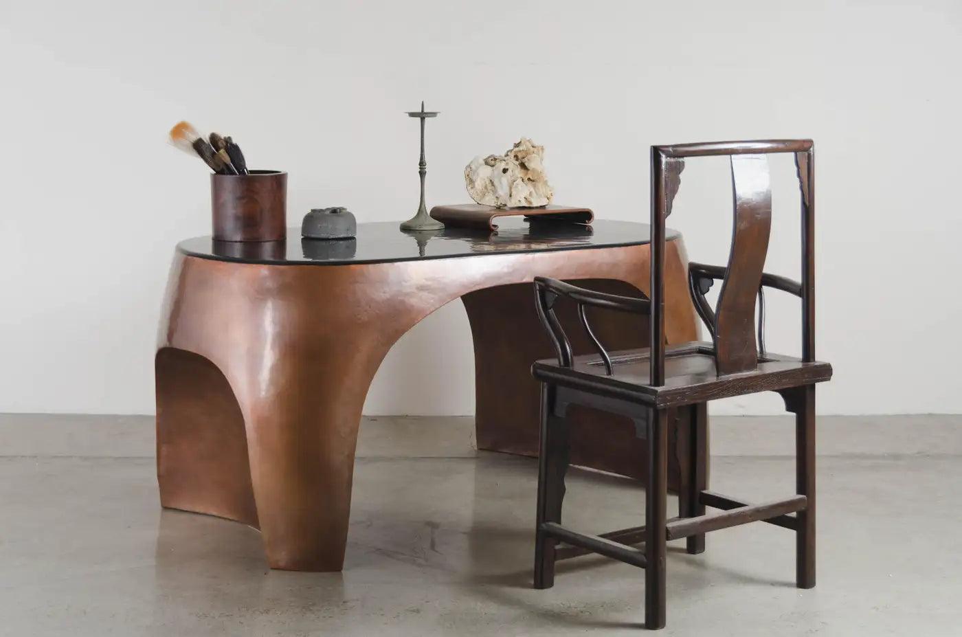 Wooden desk with a chair on a plain background
