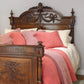 Vintage wooden bed with ornate headboard and pink bedding