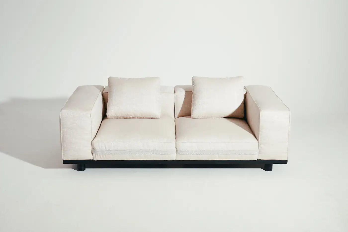 Beige sofa with black frame on a white background