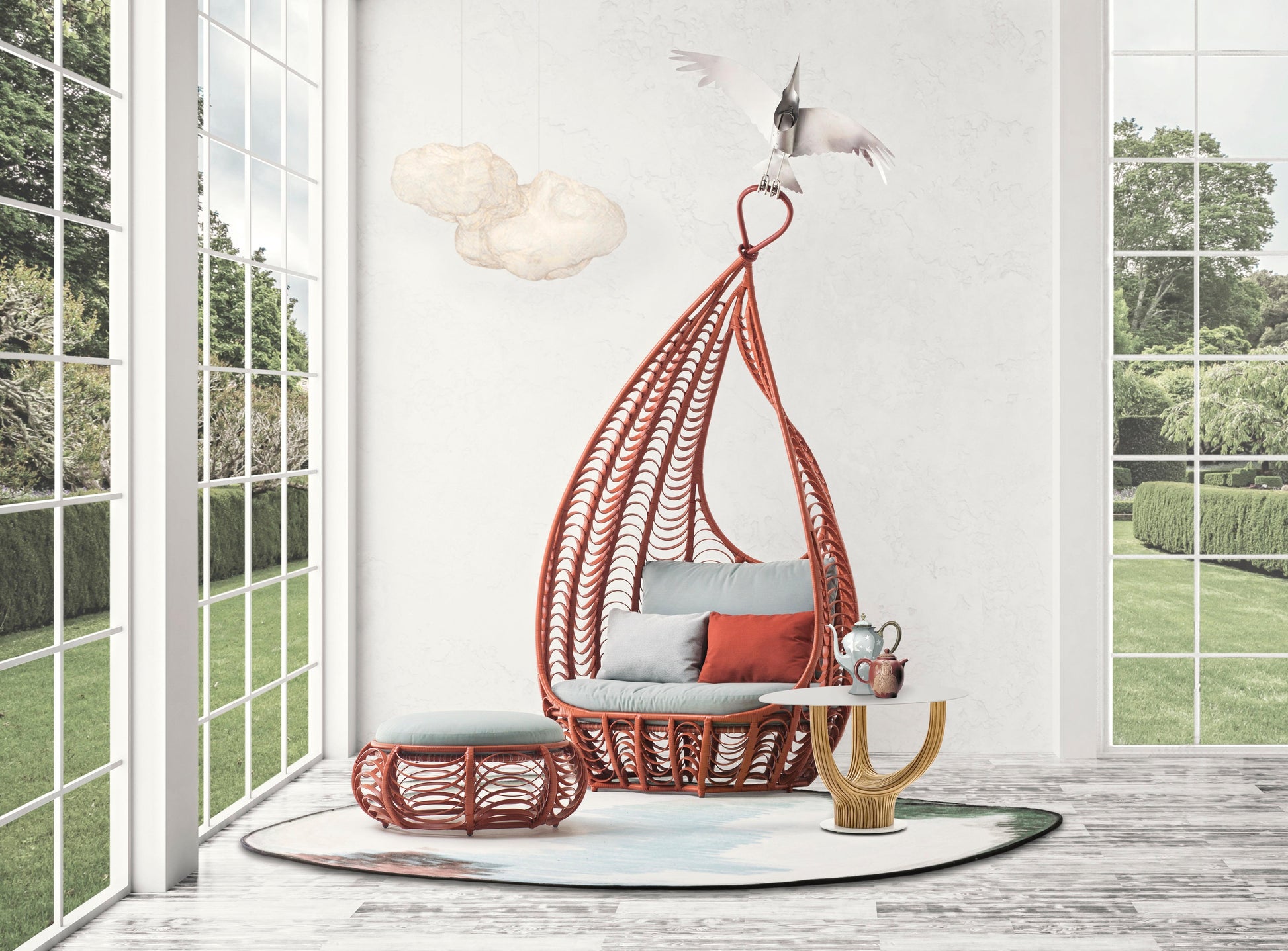 Hanging chair with cushions in a room with large windows showing greenery outside.