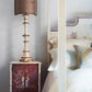 Bedroom with a lamp on a nightstand next to a bed with pillows.
