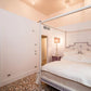 Bedroom with a four-poster bed and a lamp on a nightstand.