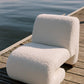 White textured chair on a wooden dock by a body of water