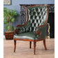 Green leather armchair with wooden frame in a room with a plant and fireplace.