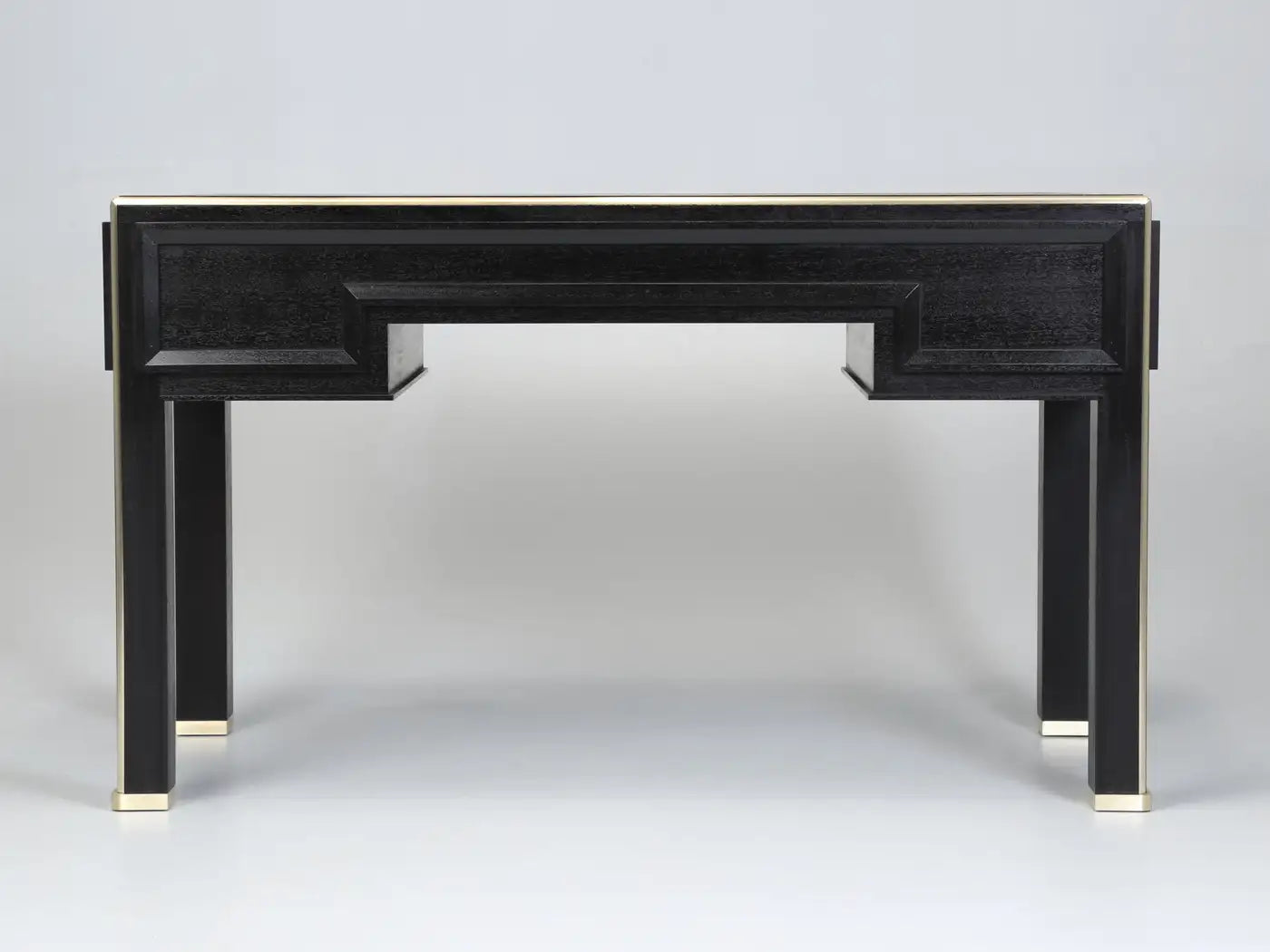 Black console table with gold accents on a gray background