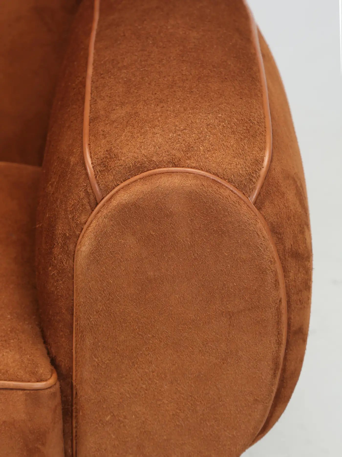 Close-up of a brown leather seat with a plain background
