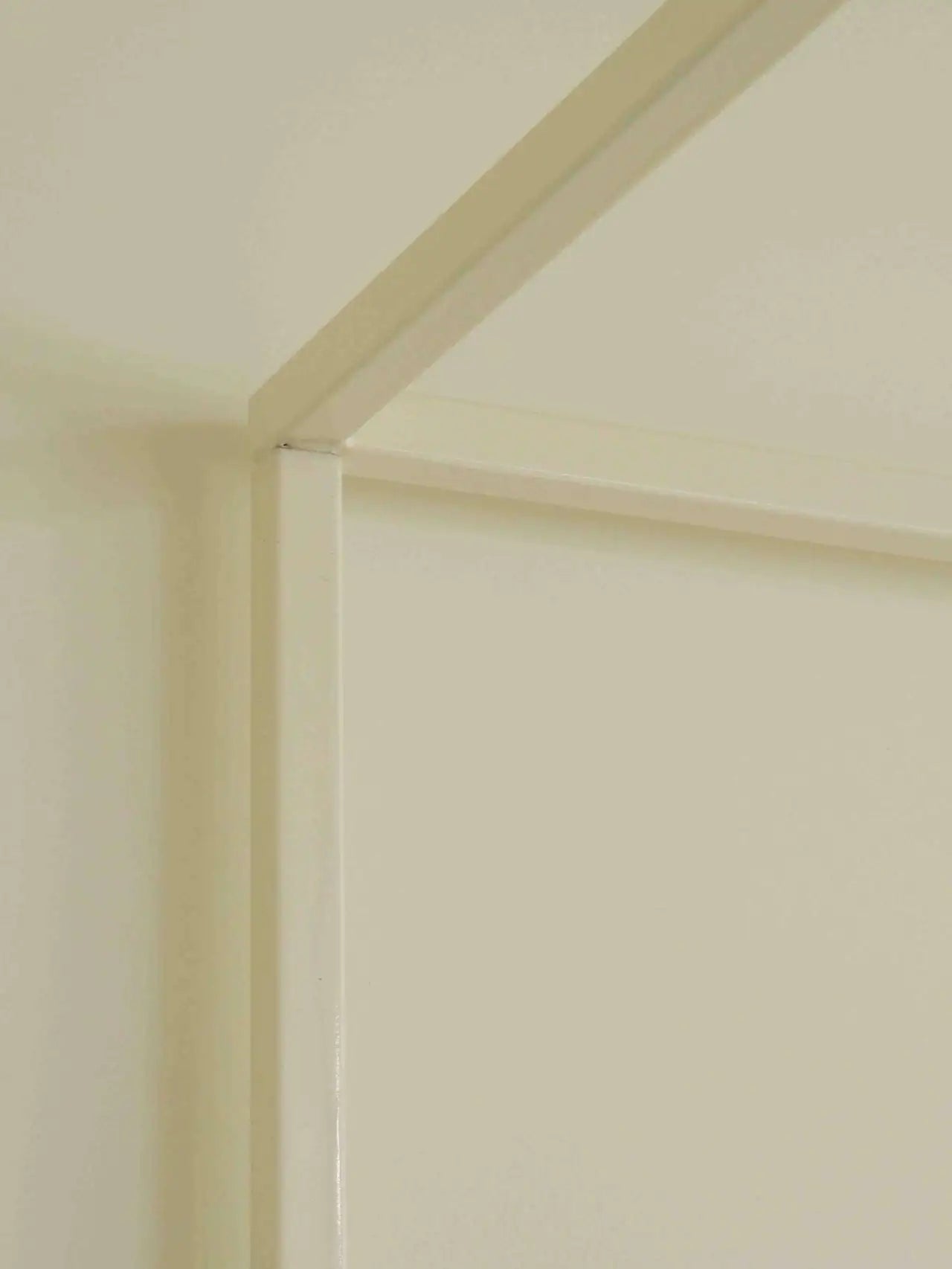 Close-up of a corner where two beige walls meet.