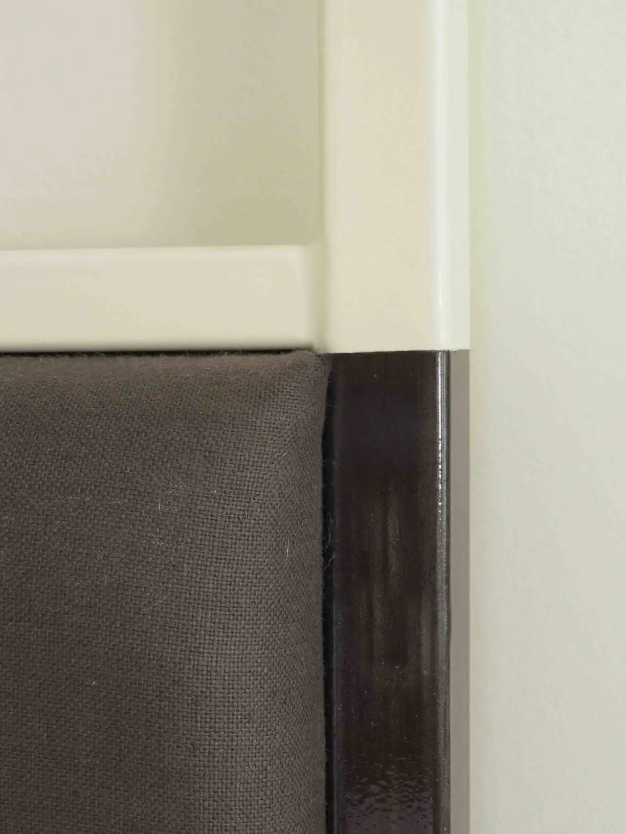 Close-up of a cabinet with a white frame and dark interior.