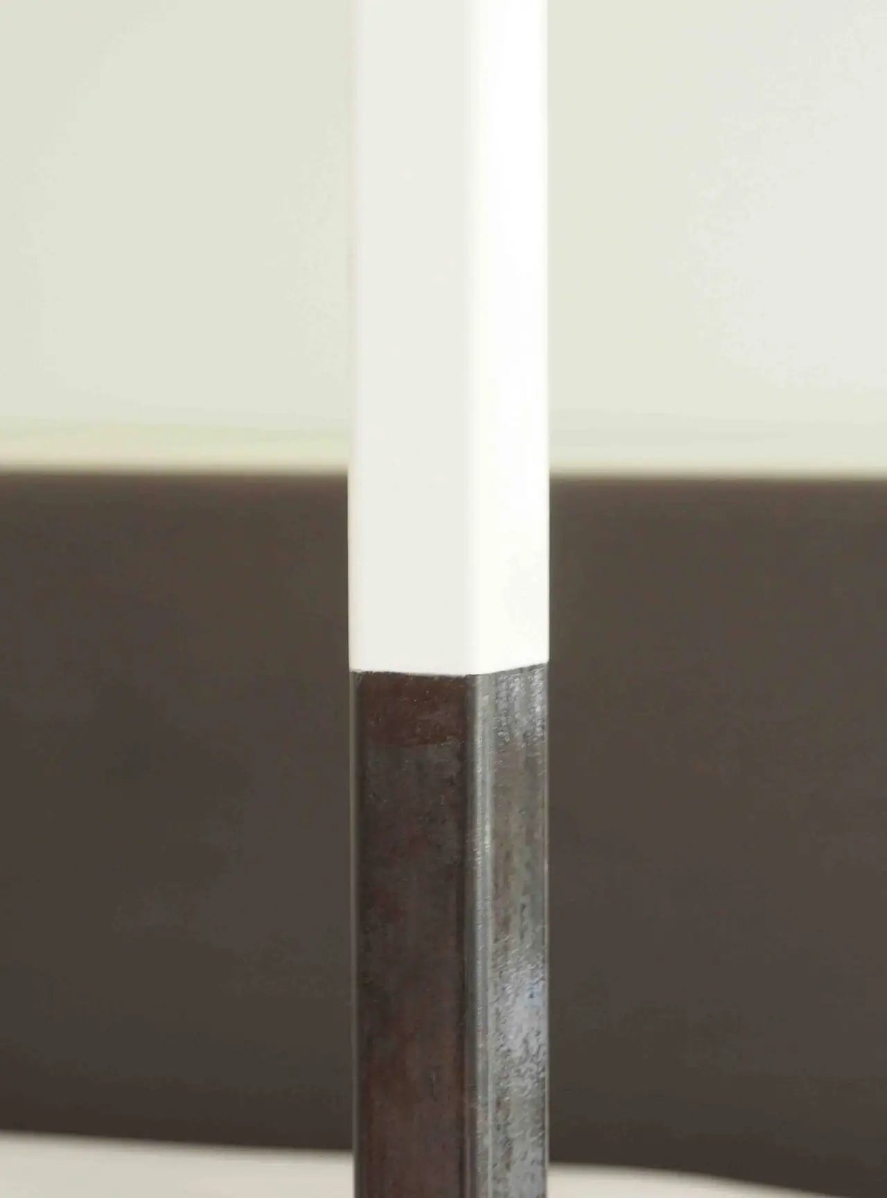 Close-up of a sword with a brown handle and white blade against a blurred background