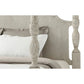 Decorative headboard with intricate carvings on a bed with white bedding.