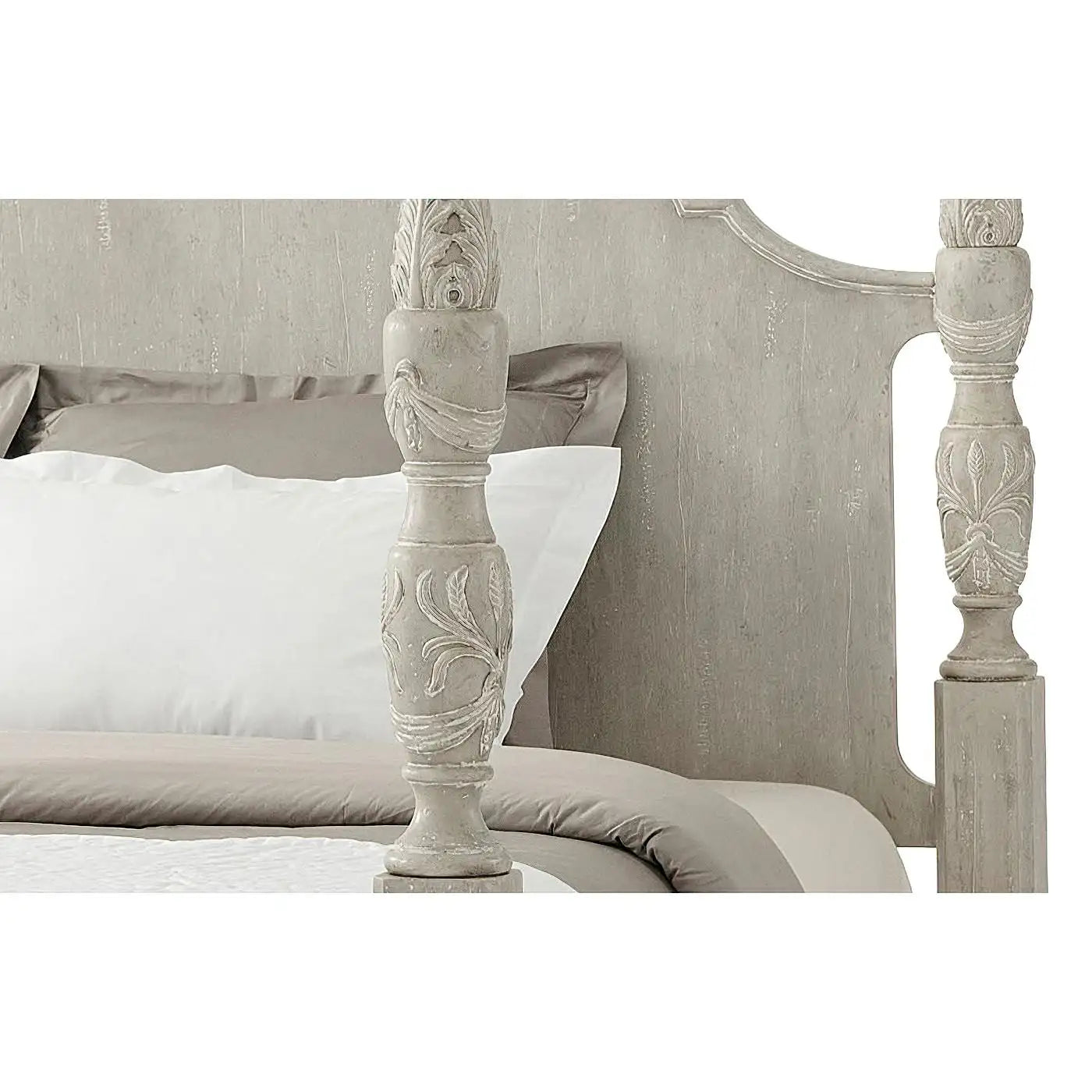 Decorative headboard with intricate carvings on a bed with white bedding.
