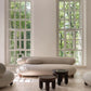 Modern beige sofa in a room with large windows and wooden flooring