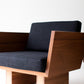 Modern chair with wooden frame and dark fabric seat on a white background