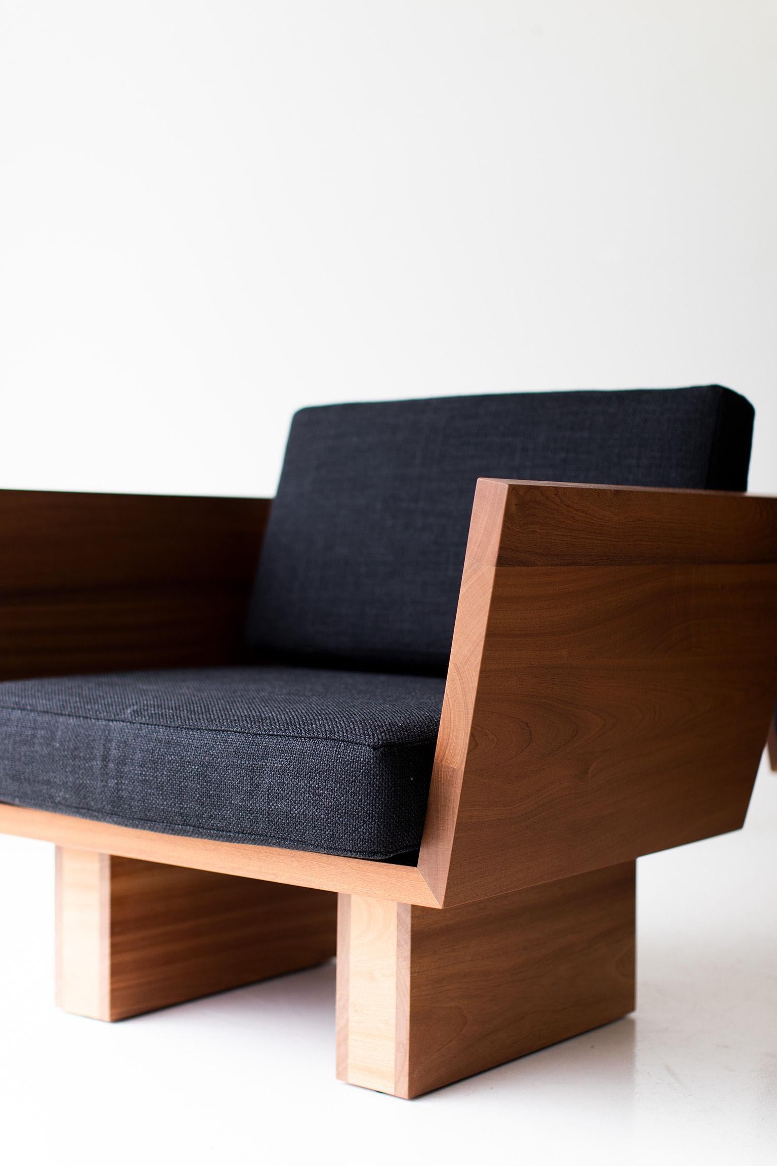Modern chair with wooden frame and dark fabric seat on a white background