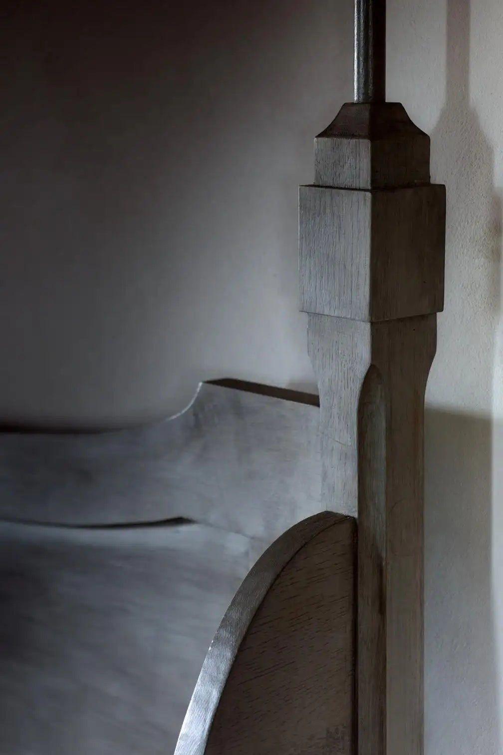 Close-up of a wooden bed frame with a neutral background
