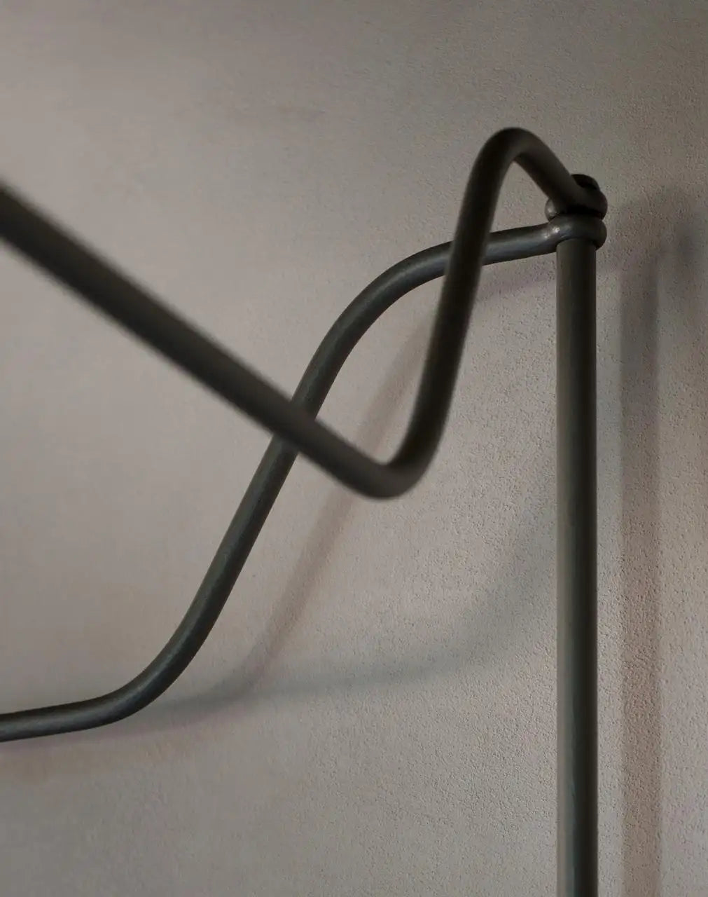 Metallic wall-mounted rack on a plain wall