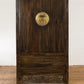 Wooden door with circular emblem on a white wall background