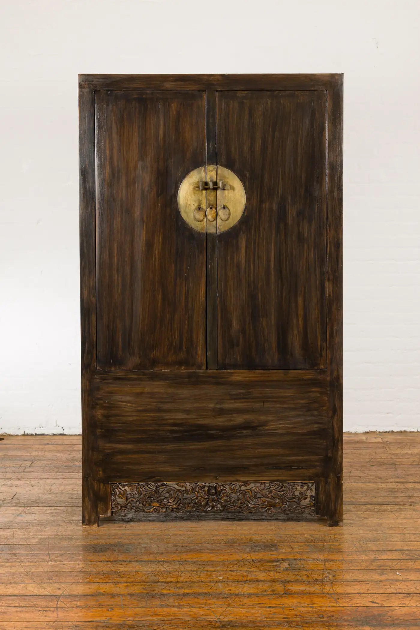 Wooden door with circular emblem on a white wall background