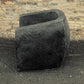 Black stone planter against a brick wall
