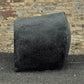 Black rubber roller against a brick wall