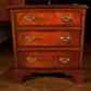 Wooden dresser with three drawers on a wooden floor.