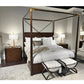 Bedroom with a four-poster bed, nightstands, and ottomans.