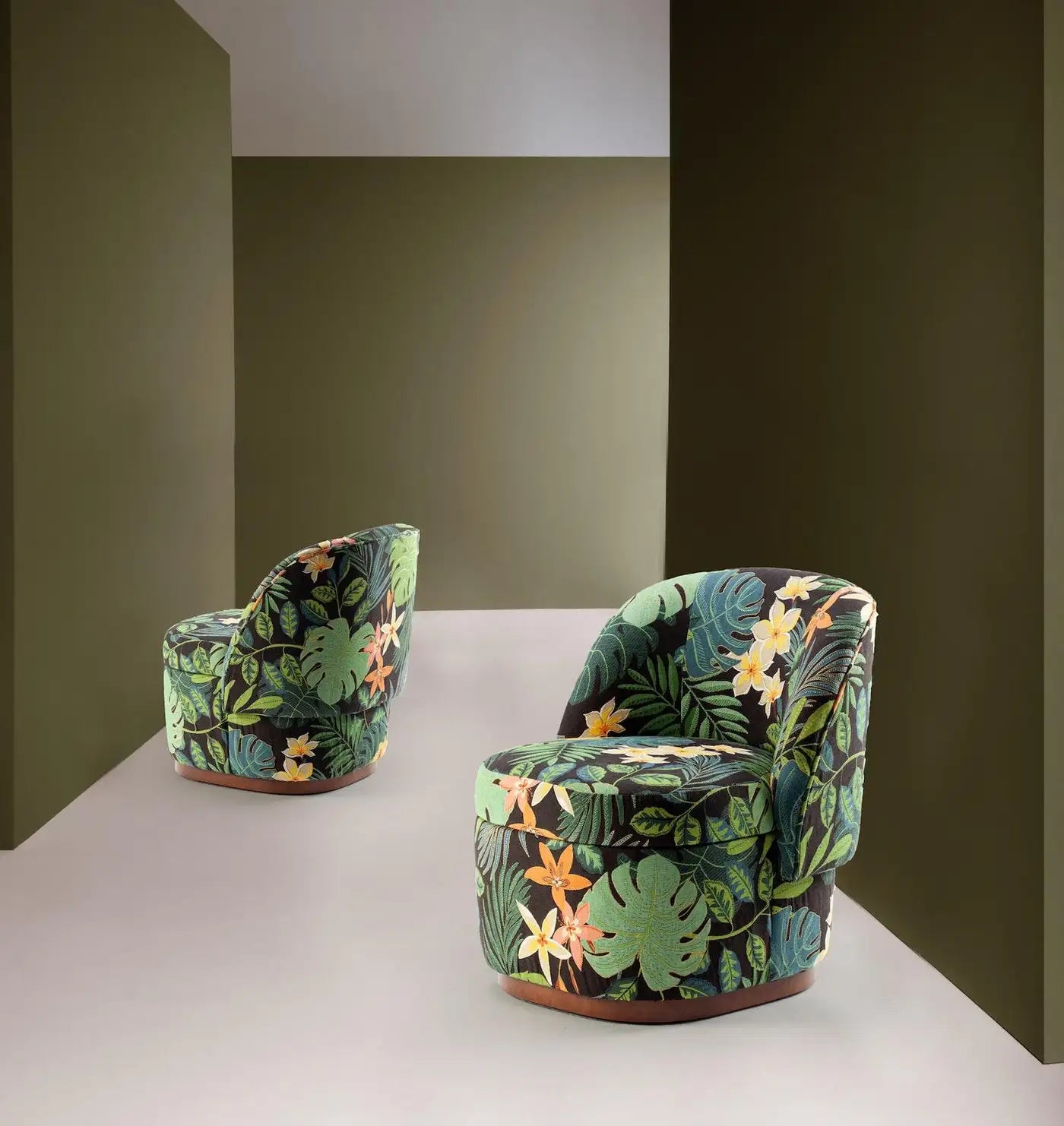 Two patterned chairs on a white platform with a dark green wall background