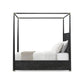 Black metal canopy bed with white bedding on a white background