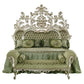 Decorative bed with ornate silver headboard and green bedding on a white background