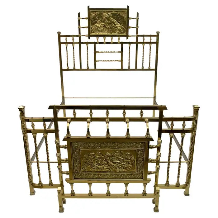 Decorative gold metal bed with intricate designs on a white background