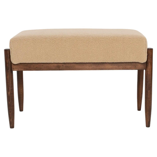 Beige cushioned bench with wooden legs on a white background