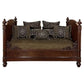 Decorative wooden bed with patterned cushions on a white background