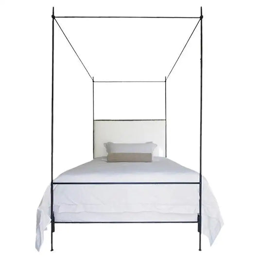 Black metal canopy bed with white bedding on a white background
