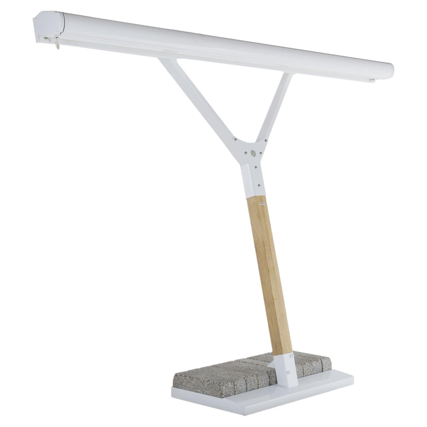 Desk lamp with a white shade, wooden base, and gray cushion on a white background
