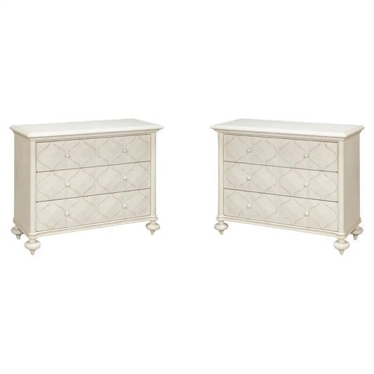 Two white dressers with decorative patterns on a white background