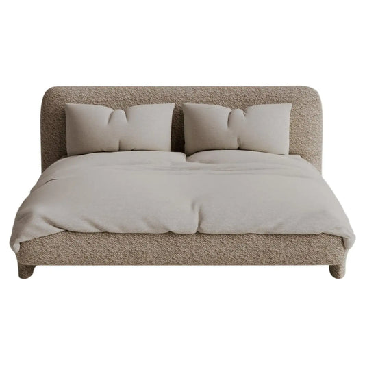 Beige upholstered bed with matching bedding on a white background