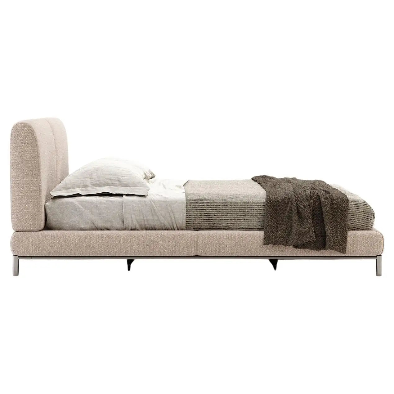 Beige upholstered bed with bedding on a white background