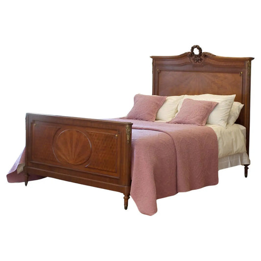 Wooden bed with pink bedding on a white background
