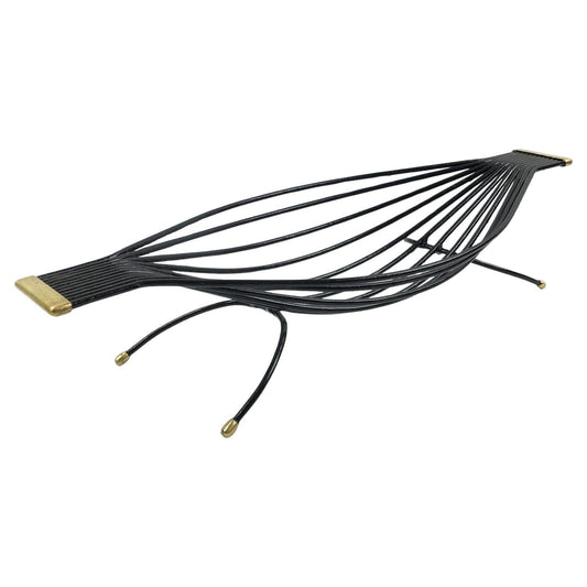 Black metal leaf-shaped object with gold accents on a white background