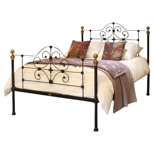 Decorative metal bed with bedding on a white background