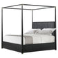 Black metal canopy bed with white bedding on a white background