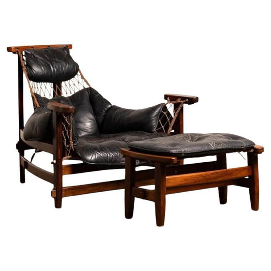 Vintage lounge chair with wooden frame and black leather cushions on a white background