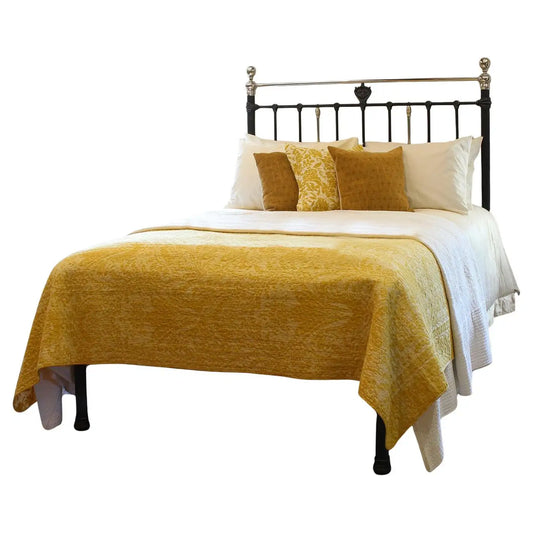 Bed with yellow blanket and pillows on a white background