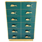 Teal dresser with gold fish-shaped handles on a white background