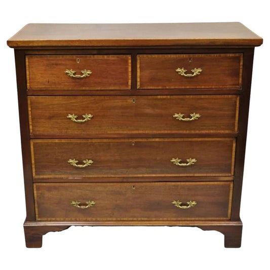 Wooden dresser with four drawers and brass handles on a white background