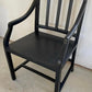 Black wooden chair against a white wall