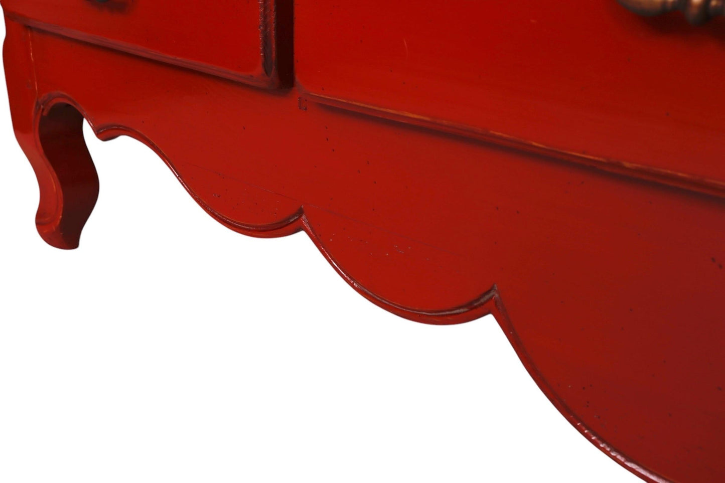 Close-up of a red decorative item with scalloped edge on a white background